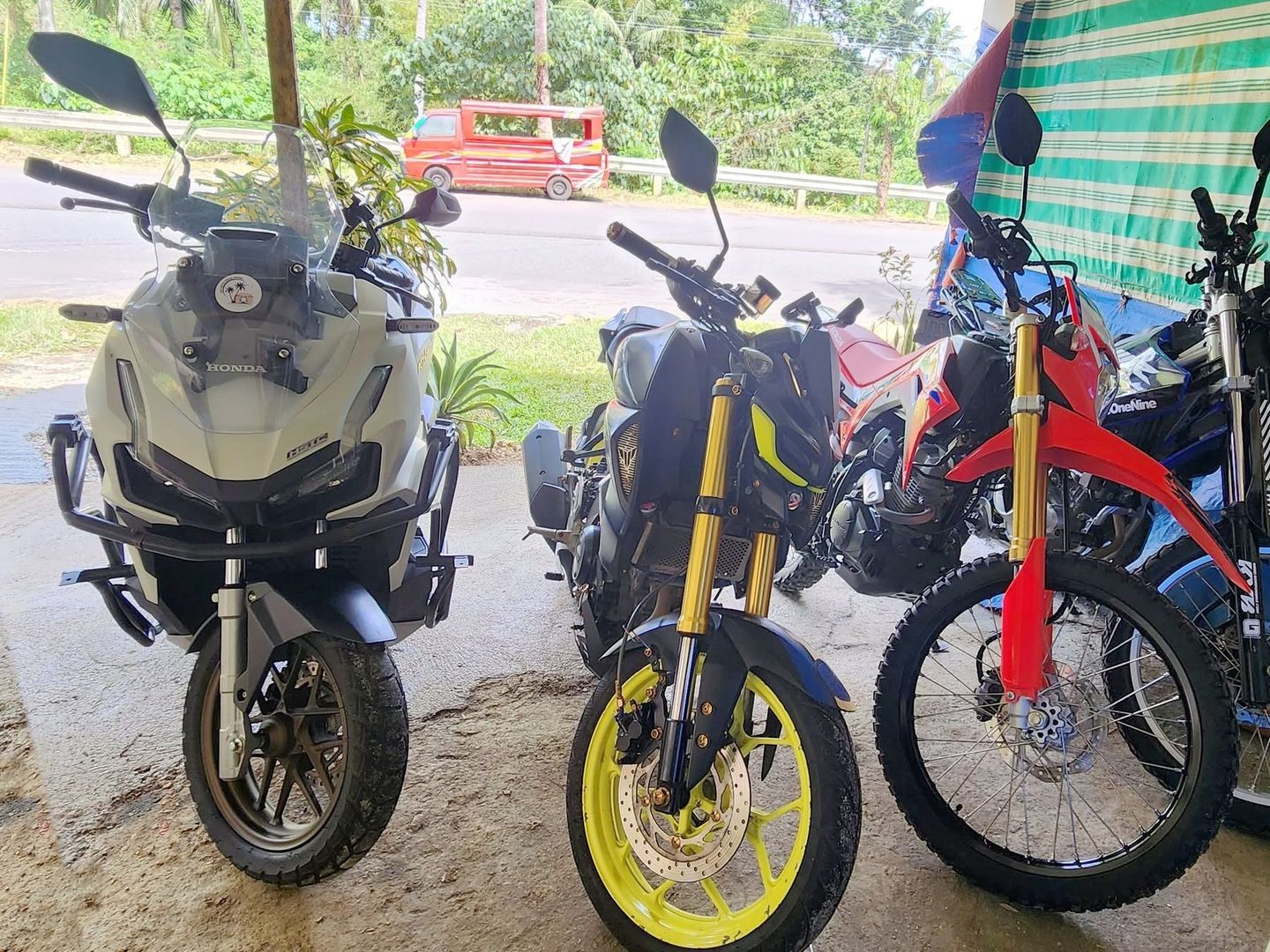 Honda ADV 160, Yamaha MT-15, Honda CRF150L dirt bikes and a Yamaha WR155R parked side by side at the rental shop